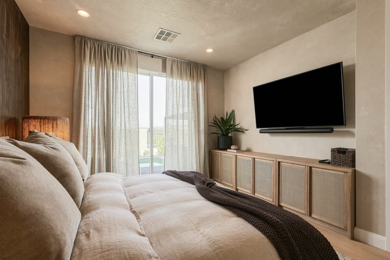 Styled Zephyr House bedroom with rattan media console and desert light