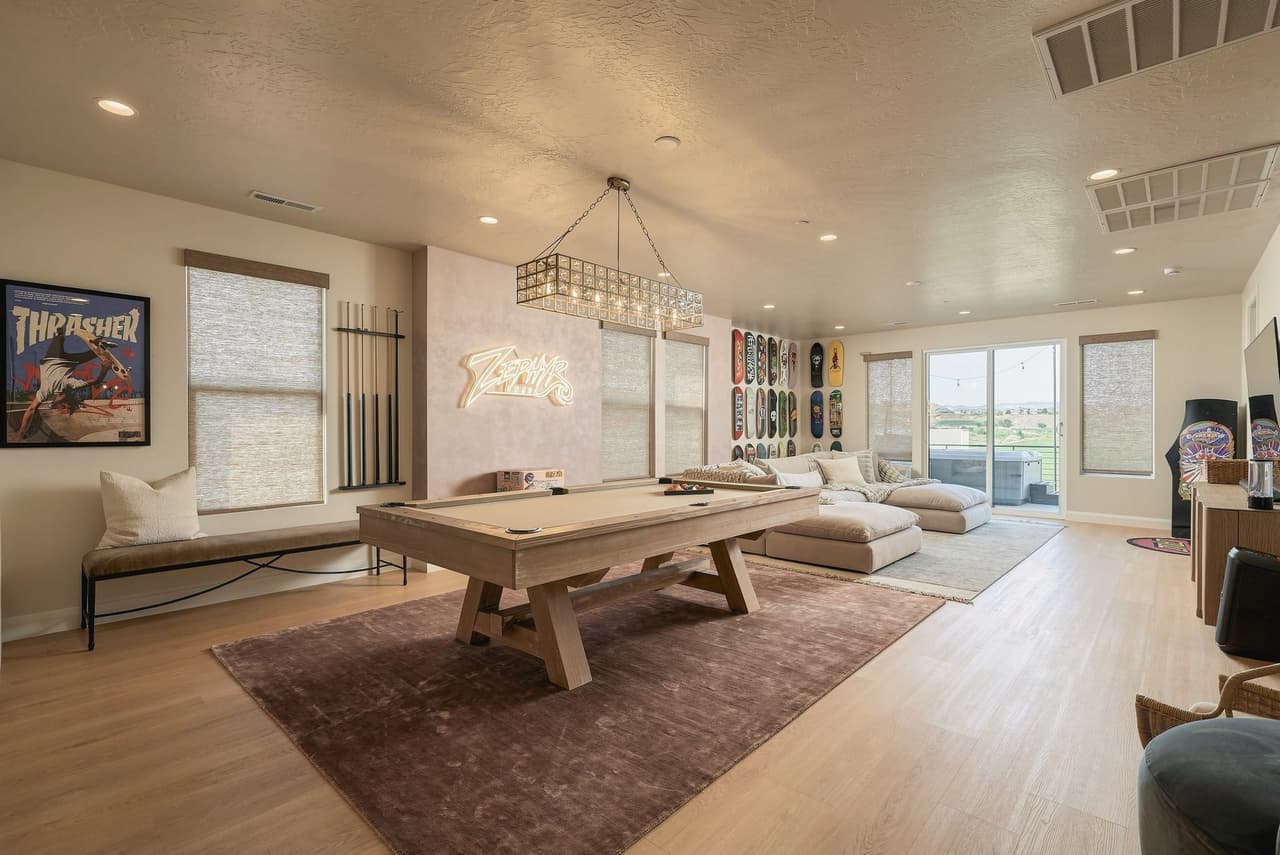 Skate rec room at Zephyr House — pool table, skate-deck wall, arcade, and Zephyr neon