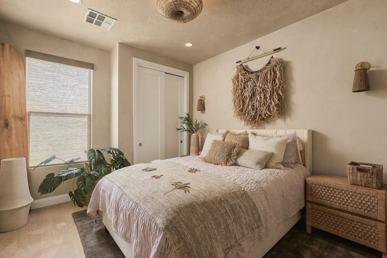 Island Zen Suite at Zephyr House — white and tan textures, woven lighting, and a standing surfboard